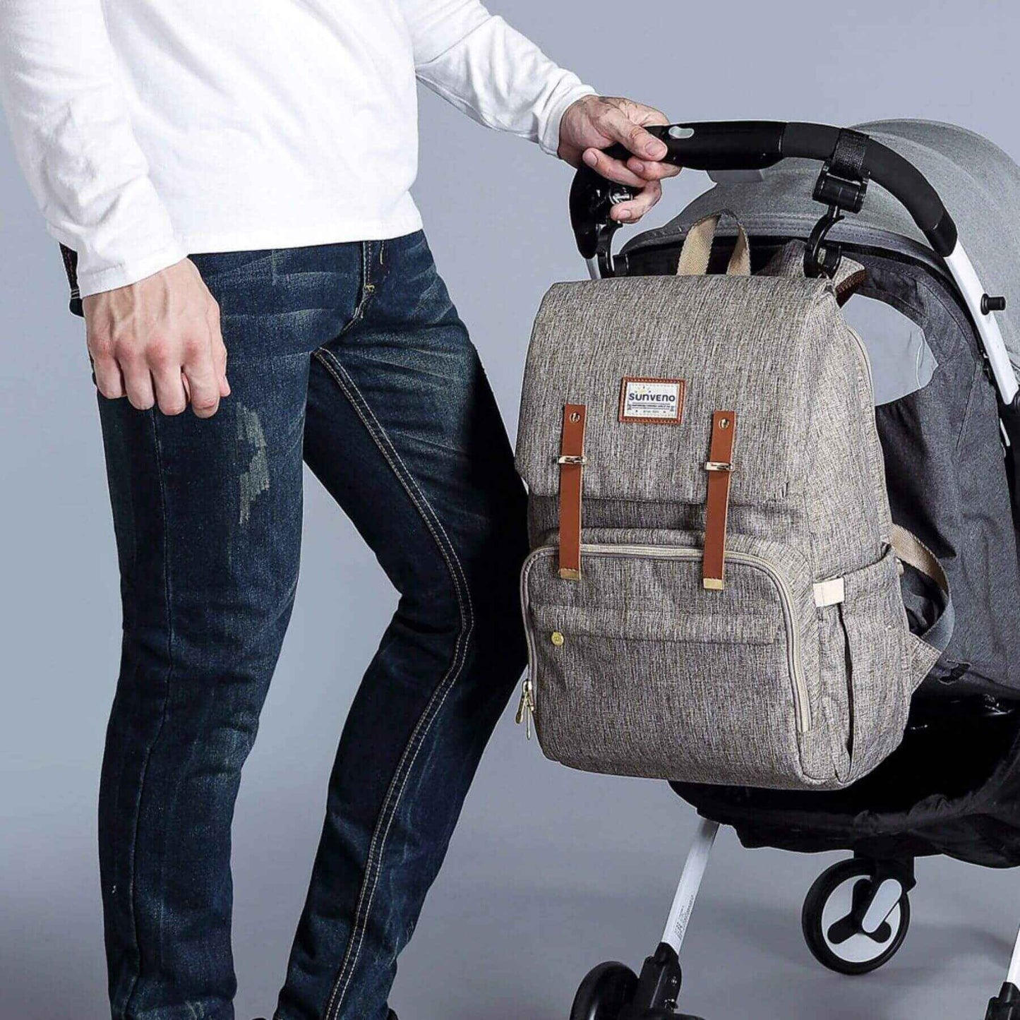 Man pushing a stroller with Sunveno Canvas Diaper Backpack - Brown