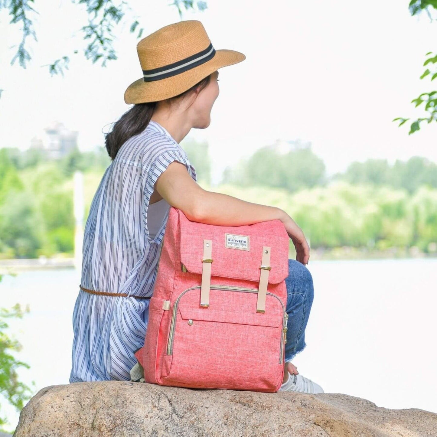 Woman sitting in a part, with Sunveno Canvas Diaper Backpack - Pink