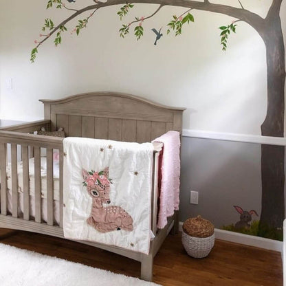 Nursery room with a crib, decorative wall, and children's items.
