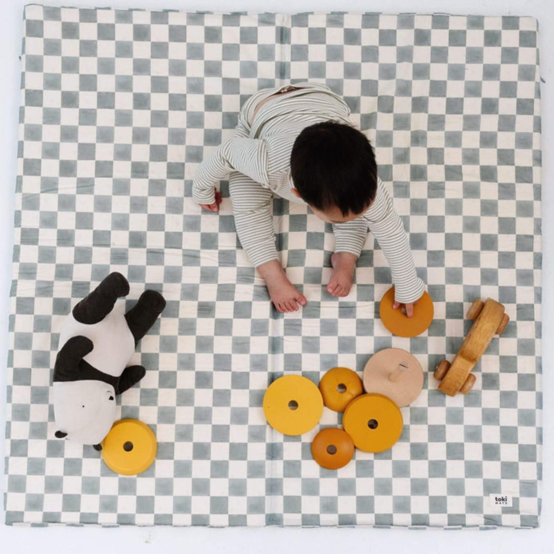 Child playing on Toki Kids Checker Matcha Organic Cotton Mat with toys
