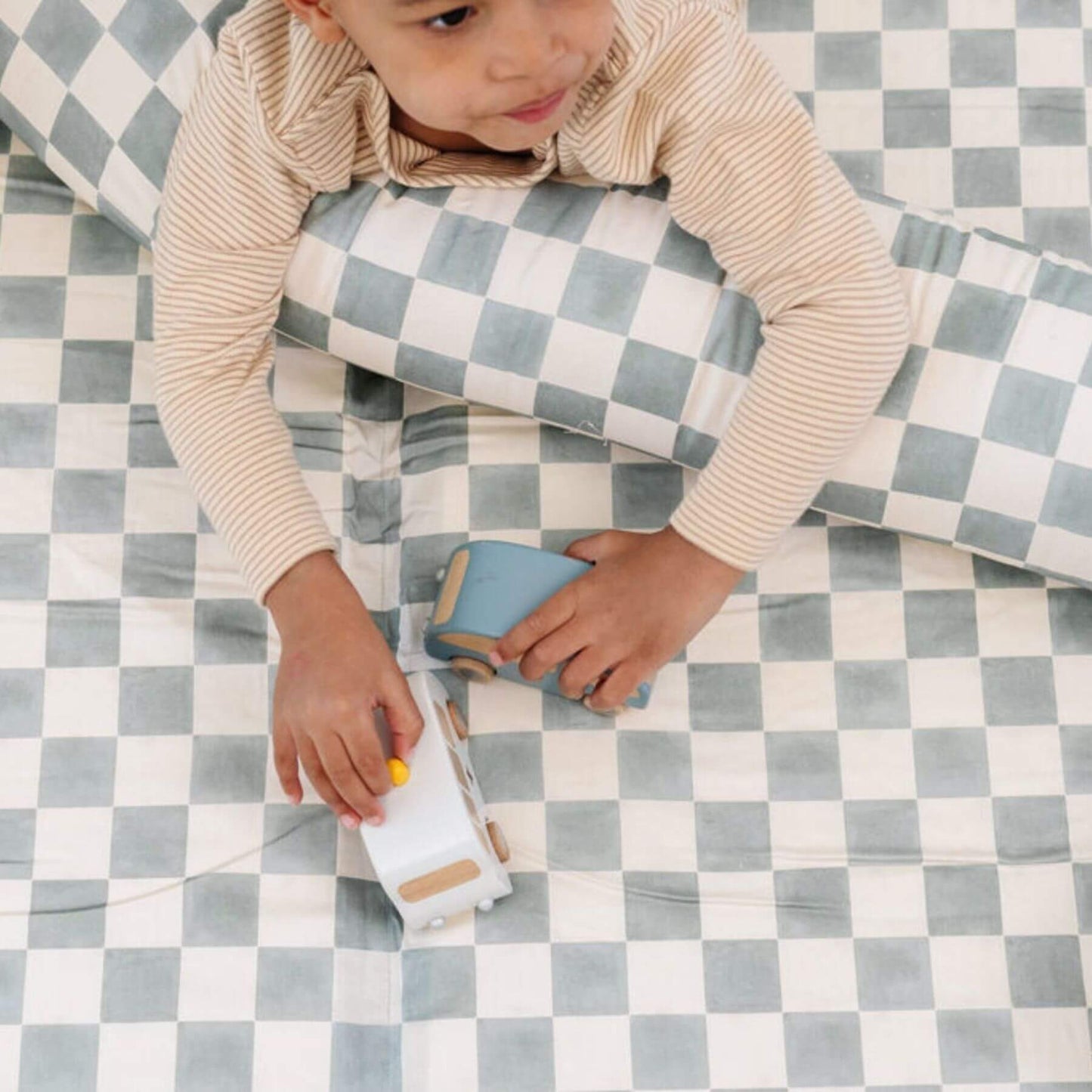 Child playing with toys on Toki Kids Checker Matcha Organic Cotton Mat
