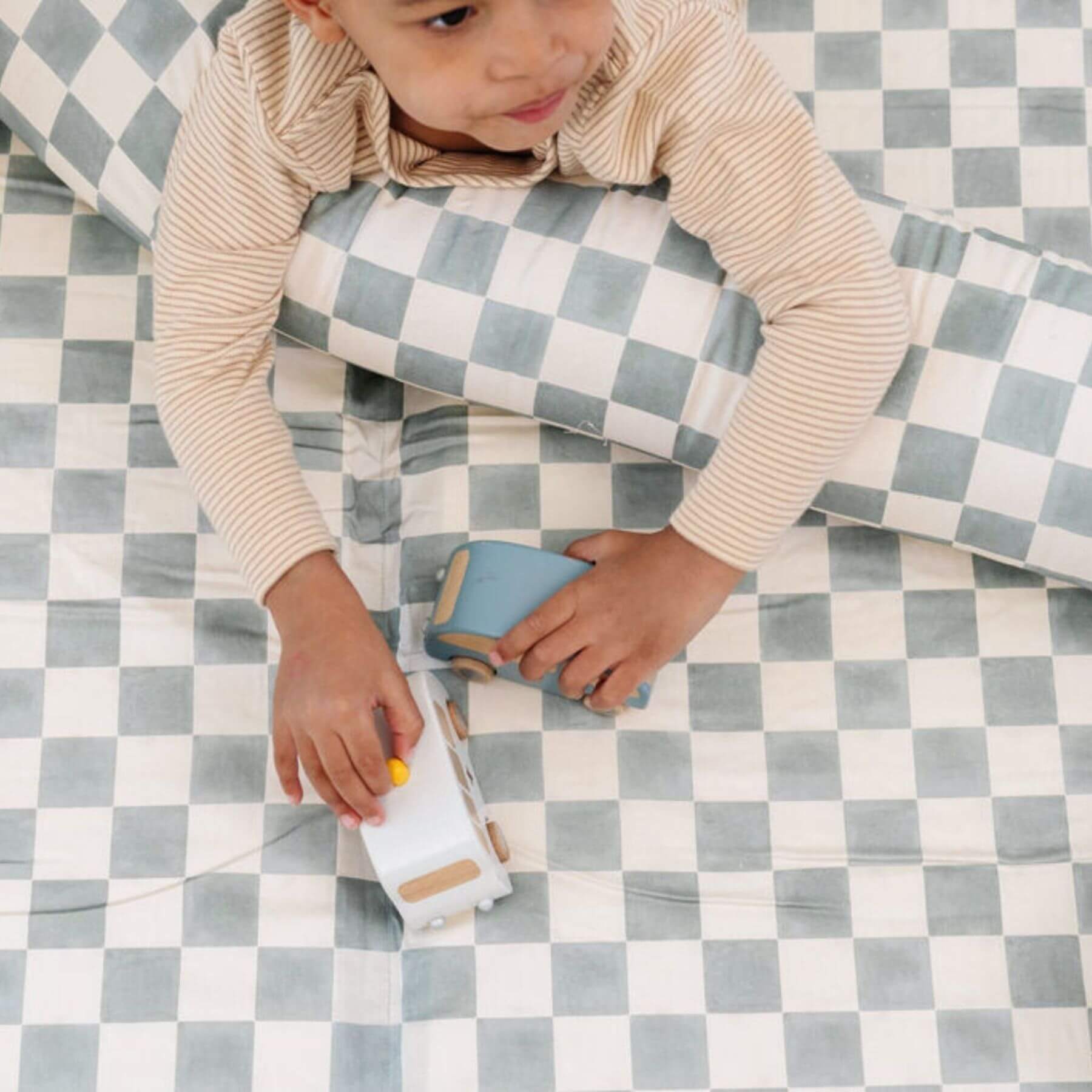 Child playing with toys on Toki Kids Checker Matcha Organic Cotton Mat