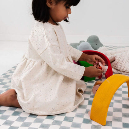 Child playing with toys on a checkered mat