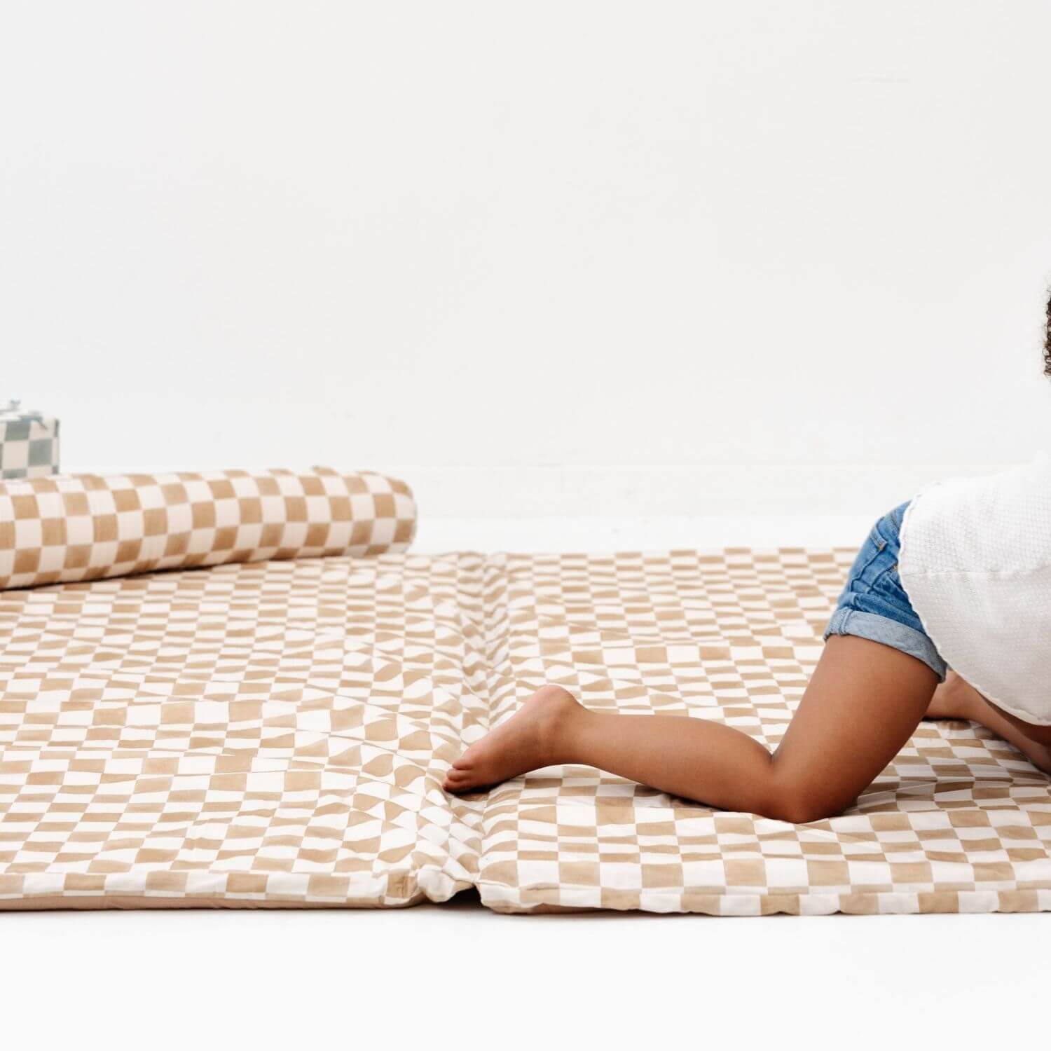 Person lying on Toki Kids Checker Toffee Organic Cotton Mat