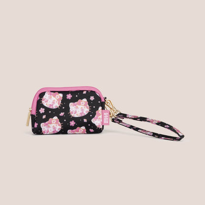 A small zip-around wristlet pouch with a black background, pink cherry blossoms, and Hello Kitty cat face prints.