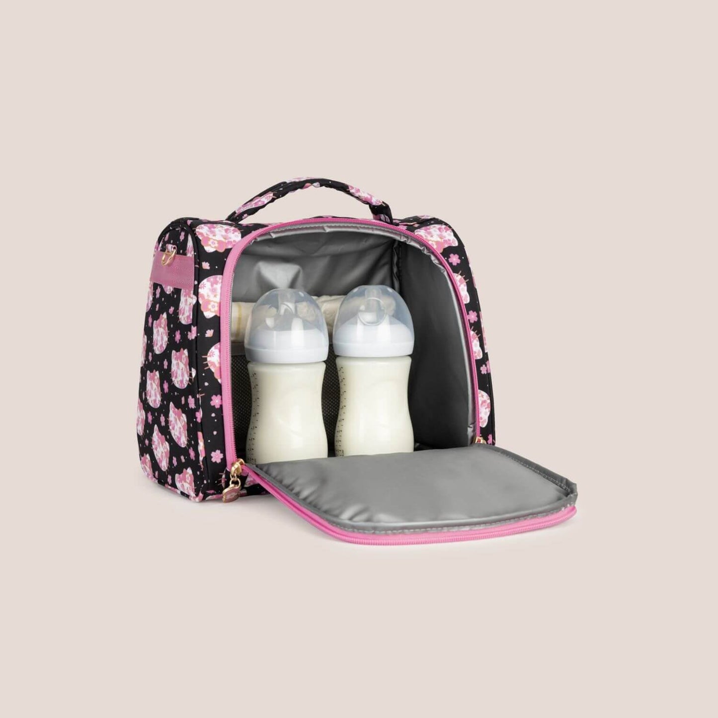 Hello Kitty® × JuJuBe Cherry Blossoms Insulated Bottle Bag with two baby bottles inside, shown open against a solid beige background.