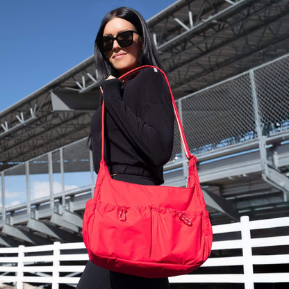 Woman carrying Cherry Motion Carryall Tote outdoors with a clear sky background