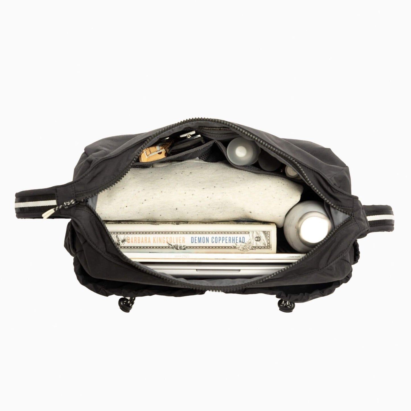 Black bag with items including a bottle labeled 'Demon Copperhead' on a white background