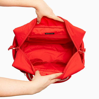 Cherry Motion Overnight Duffle held open by a person's hands