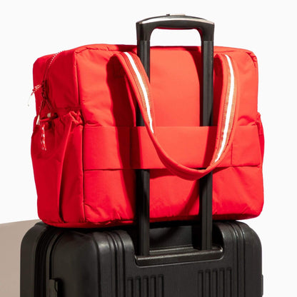 Cherry Motion Overnight Duffle on top of a black suitcase.