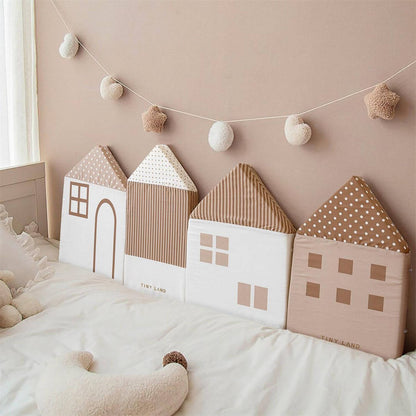Tiny Land® Children's Back Cushions on a bed with a string of pom-poms above.
