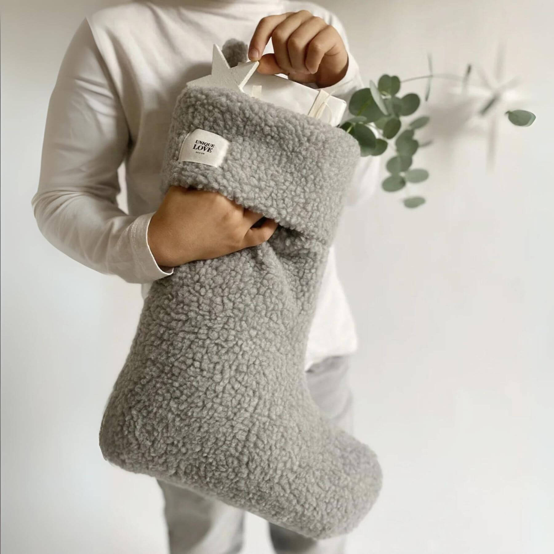 Holding a Unique Love Design Christmas Stocking Toddy Cozy Grey