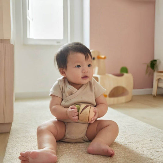 Baby Holding PlanToys Clapping Roller - Modern Rustic