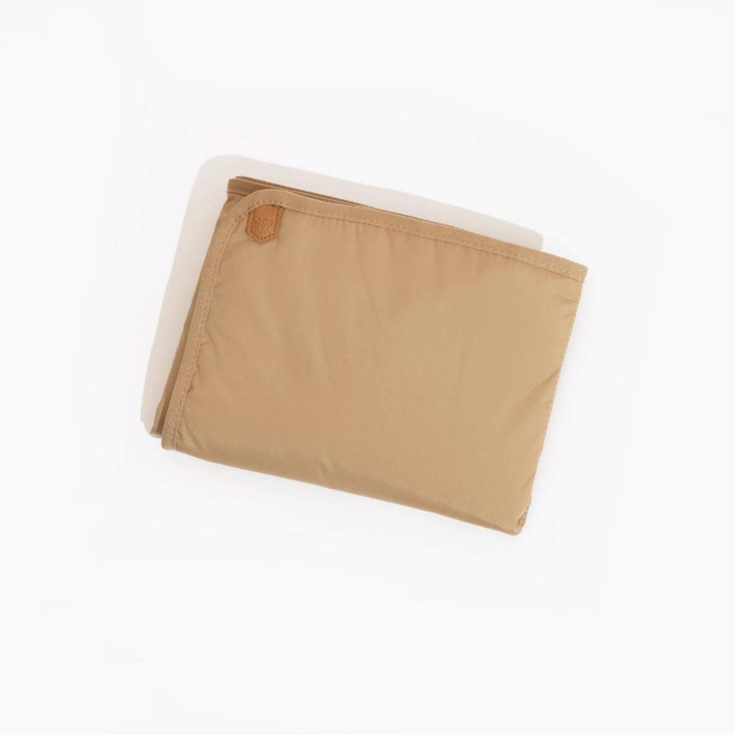 Folded beige blanket with a brand logo