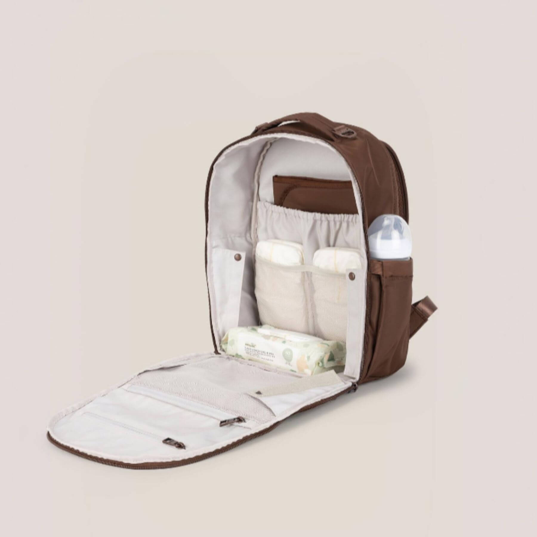 JuJuBe Classic Diaper Backpack Espresso with baby items on a beige background