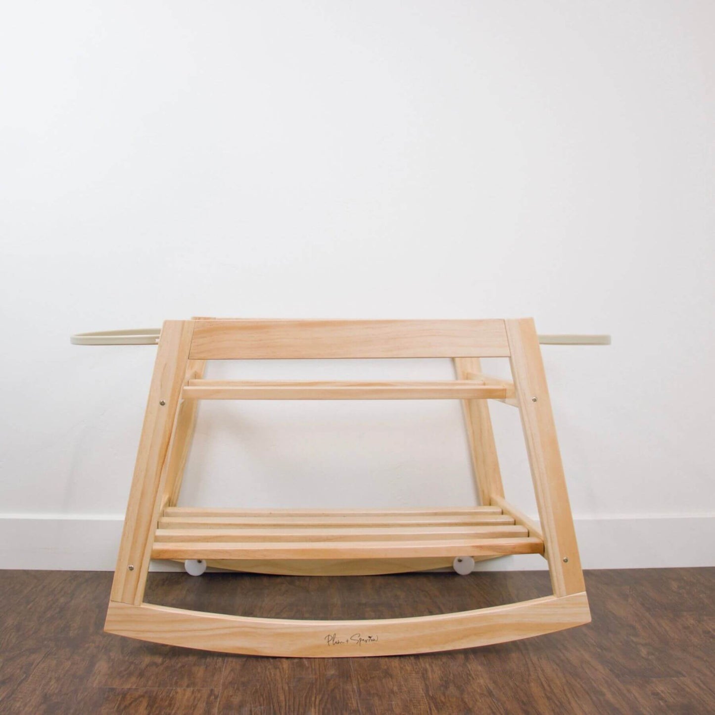 Plum+Sparrow Classic Rocking Moses Bassinet Stand with brake Natural on a wooden floor with a white wall background