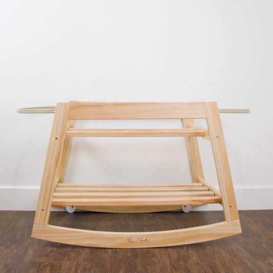 Plum+Sparrow Classic Rocking Moses Bassinet Stand with brake Natural on a wooden floor with a white wall background