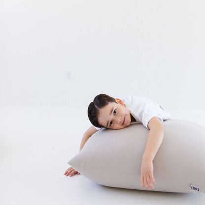 A young child rests their head and arm on Toki Kids Cloud Bean Bag