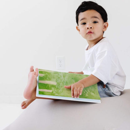 Child holding a book sitting on Toki Kids Cloud Bean Bag
