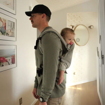 Man carrying a child in Coco Houndstooth - Woven Jacquard inside a home.