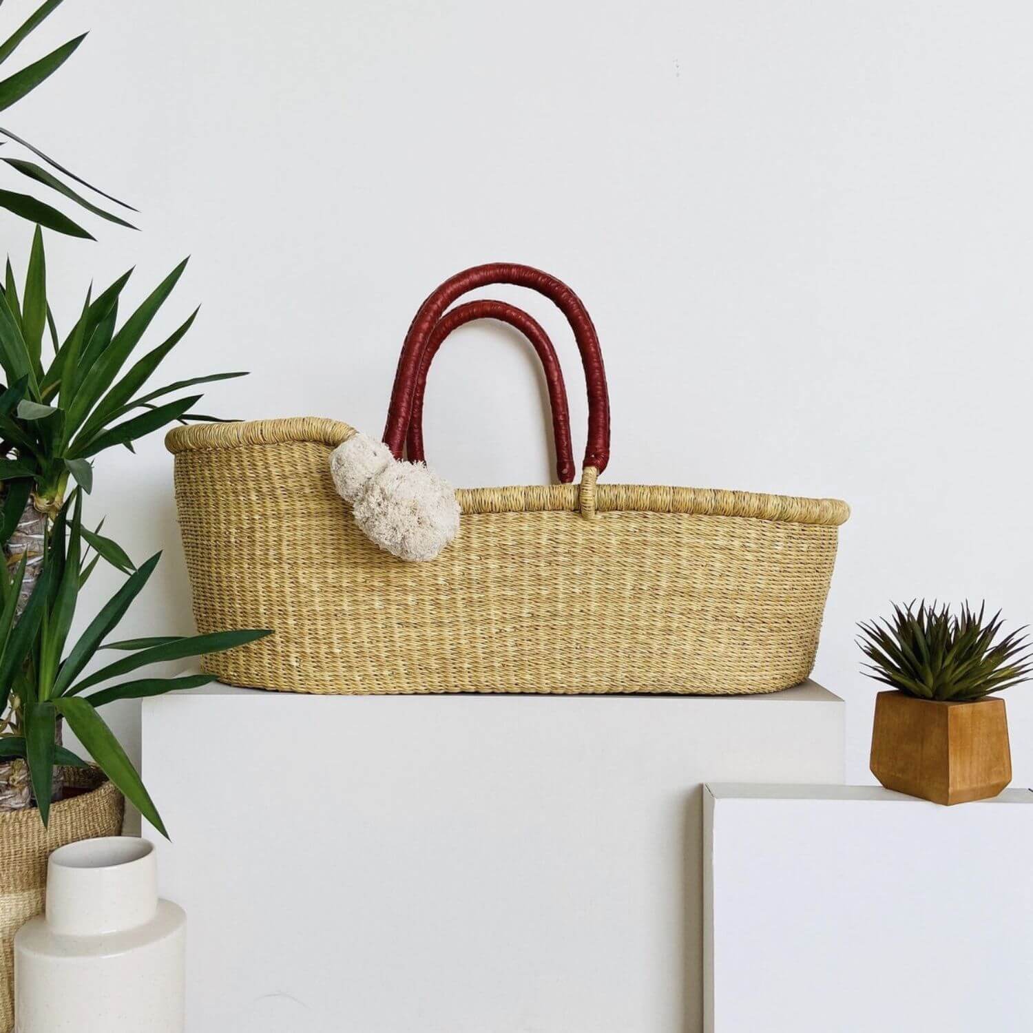 Plum+Sparrow Cognac Handle Moses Basket in a room with decor