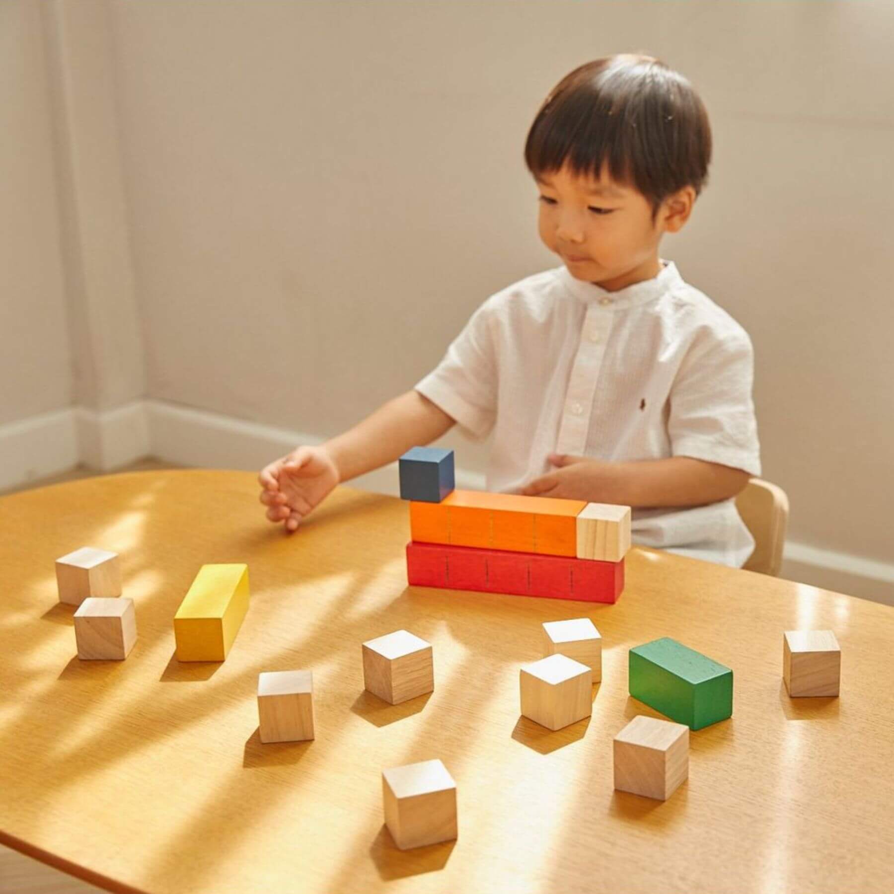 Boy Playing PlanToys Colored Counting Blocks - Unit Plus