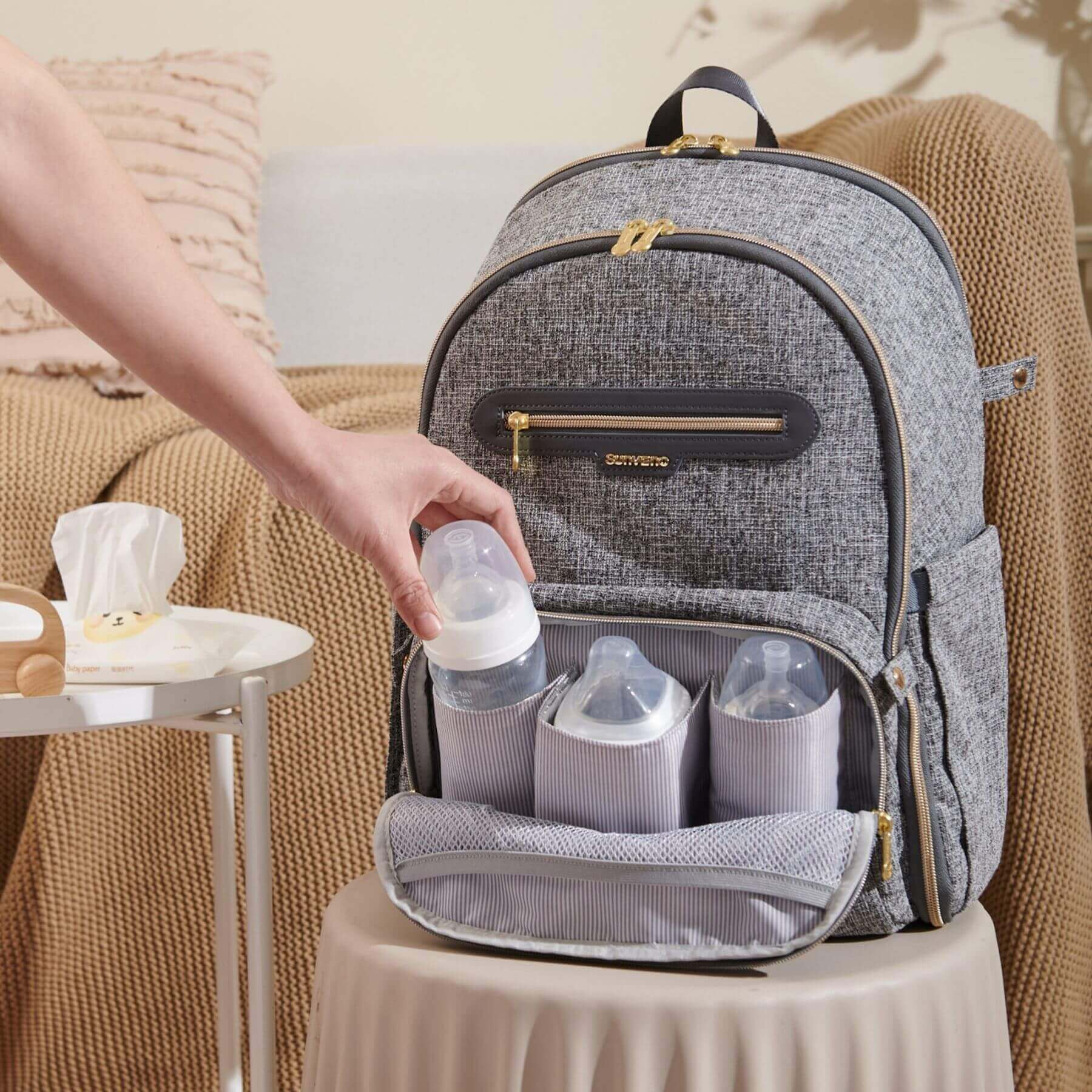 Sunveno Convertible Tweed Diaper Backpack Gray with bottles and accessories on a beige surface