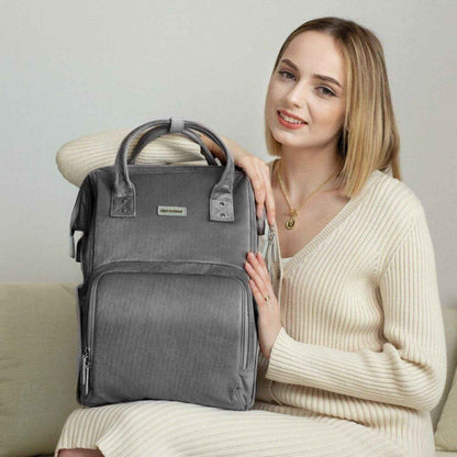 Woman holding Corduroy Diaper Backpack Grey, sitting on a couch.