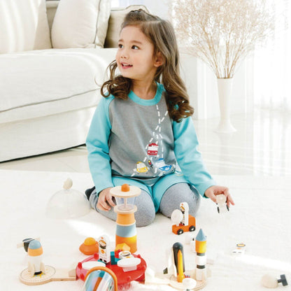 Child playing with Tender Leaf Cosmic Rocket Set on a light-colored floor.