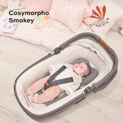 Baby in a Cosymorpho Smokey baby carrier with Cozymorpho Stroller & Seat Infant Insert on a soft surface