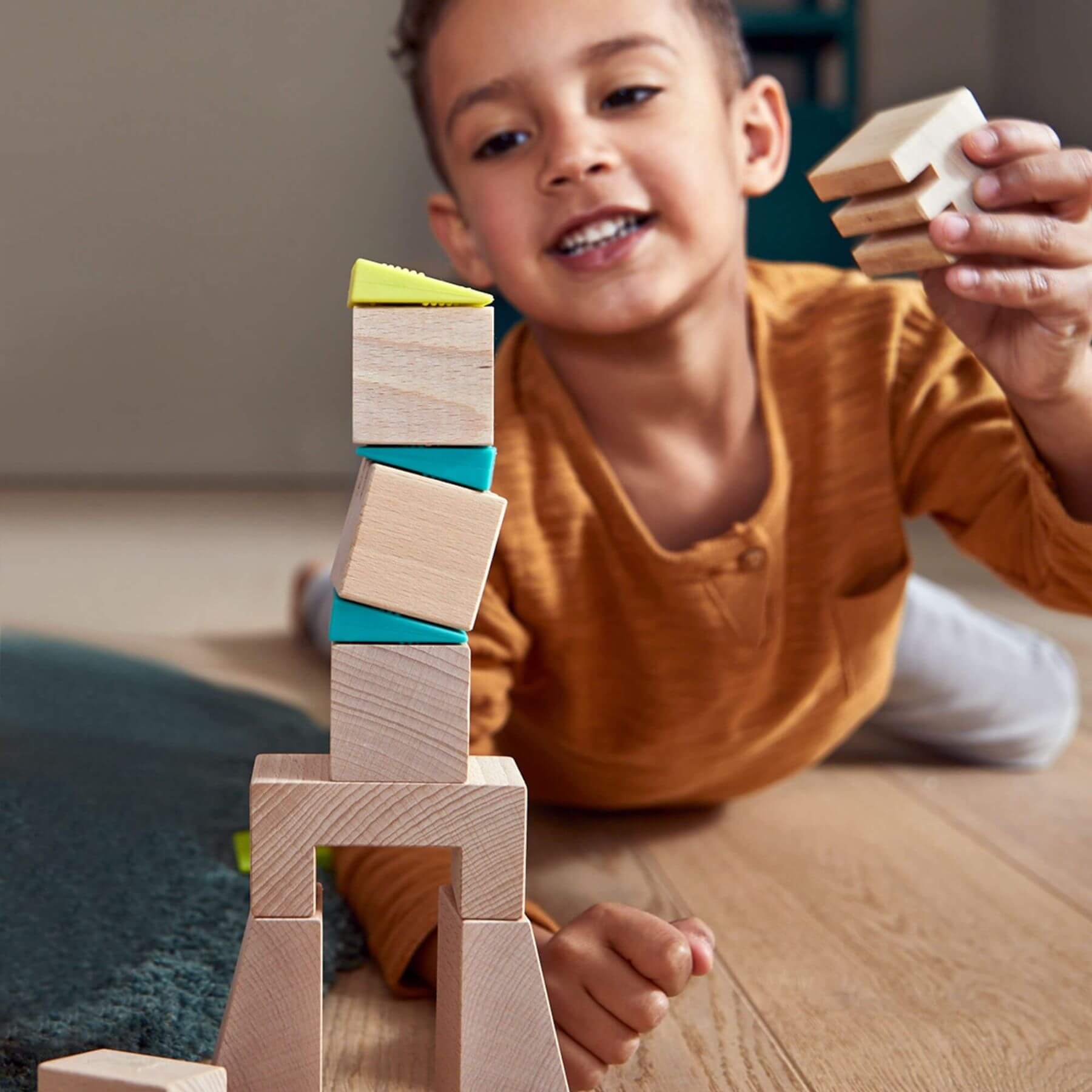 Child playing with wooden blocks on a wooden floor
