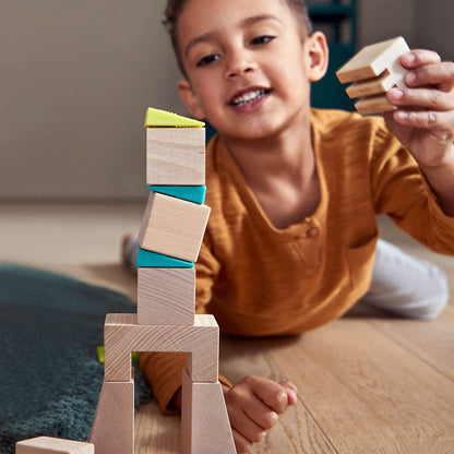 Child playing with wooden blocks on a wooden floor