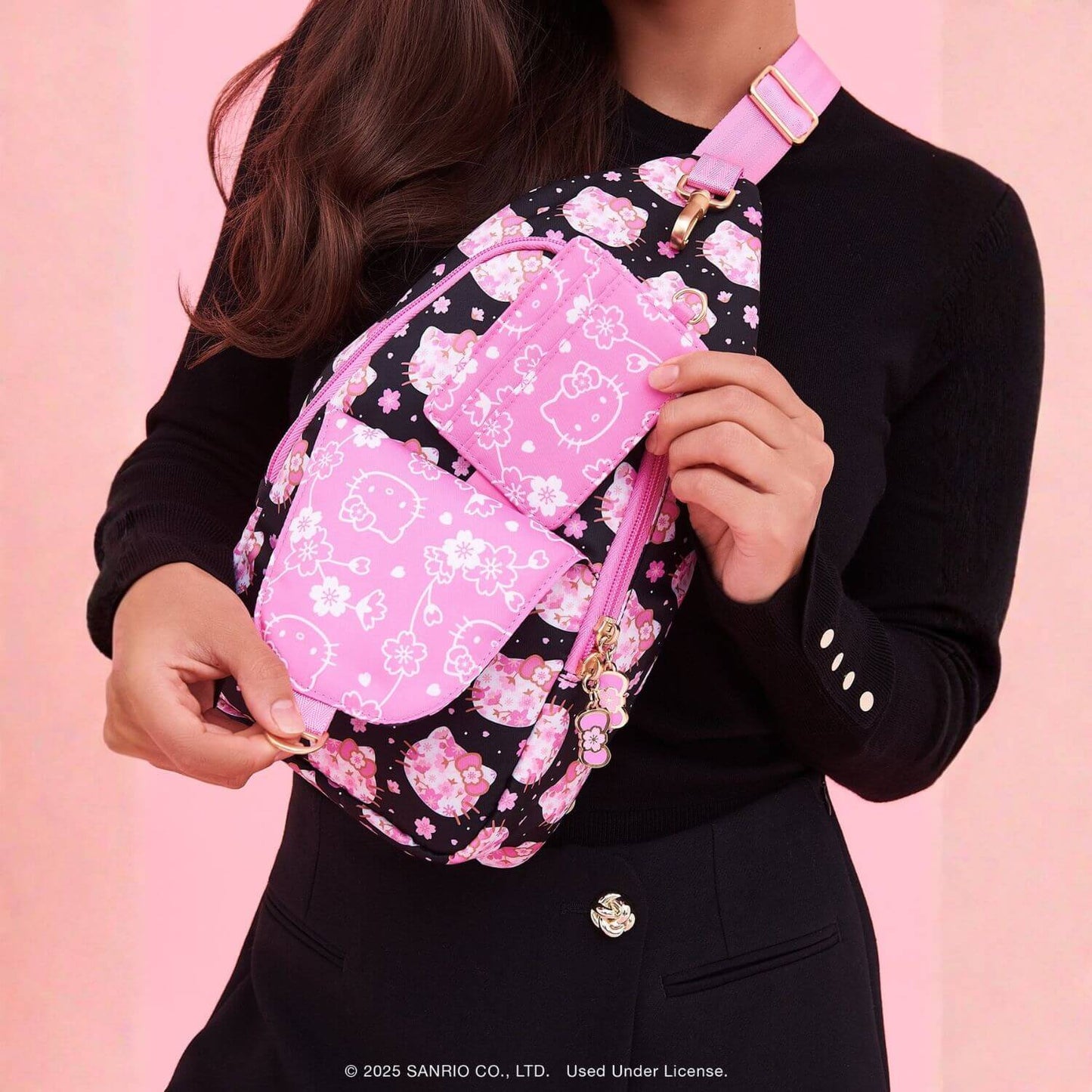 Person holding Crossbody Sling Cherry Blossoms against a pink background