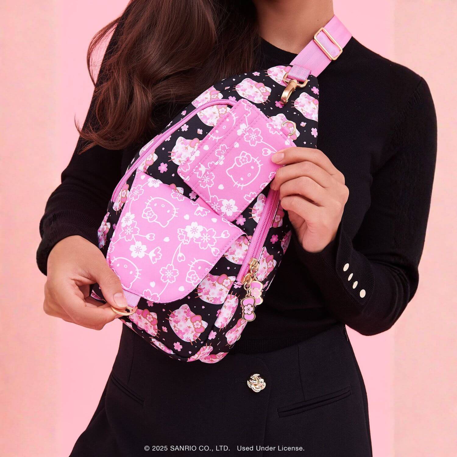 Person holding Crossbody Sling Cherry Blossoms against a pink background