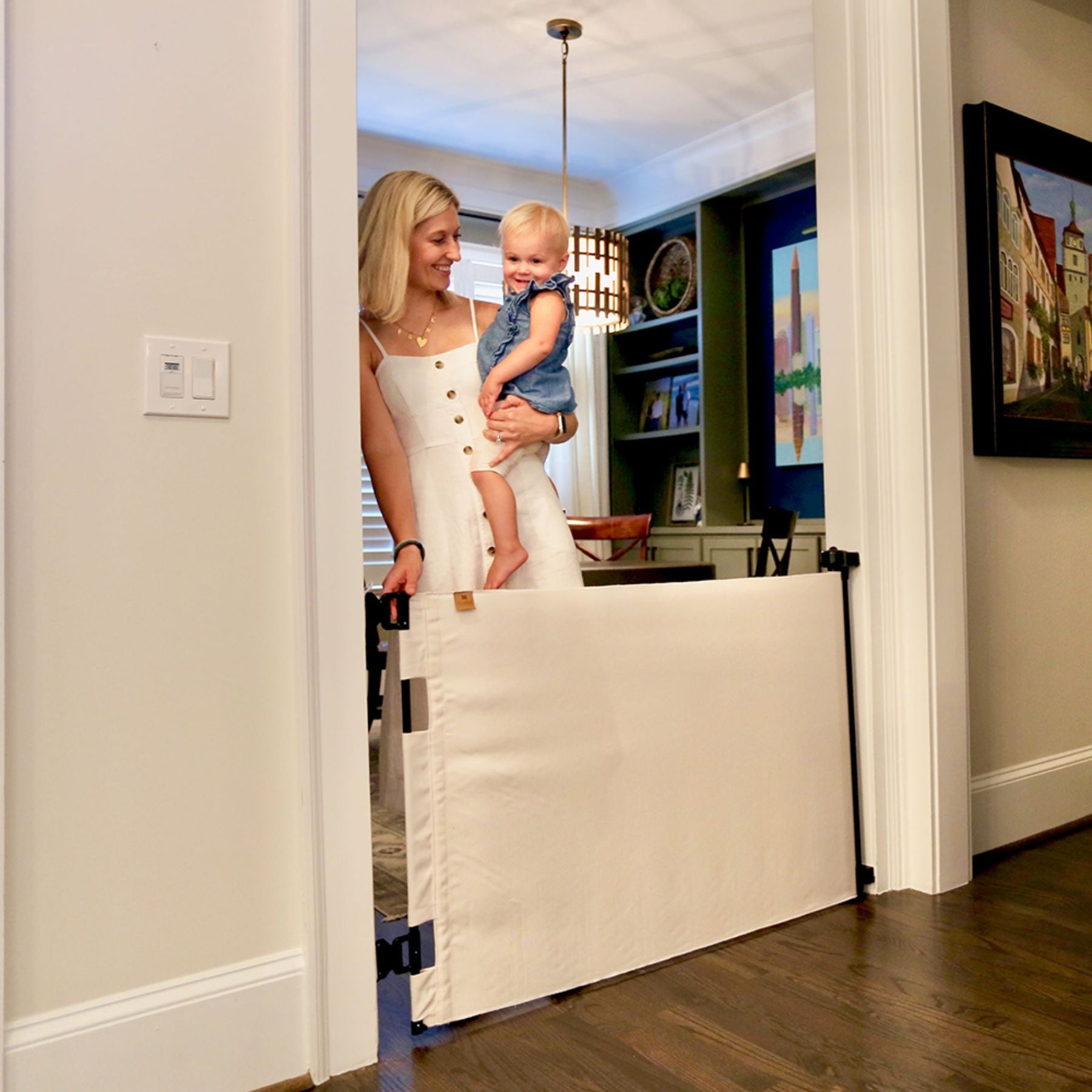 Woman holding a child behind Crypton® Fabric Baby & Pet Safety Gate -  in a home setting