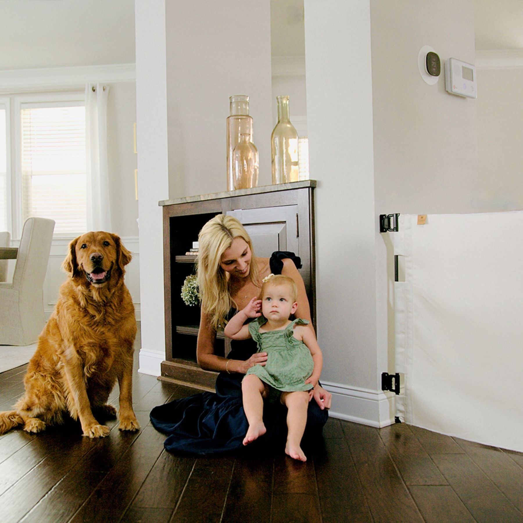 Woman holding a child and a dog in a home setting