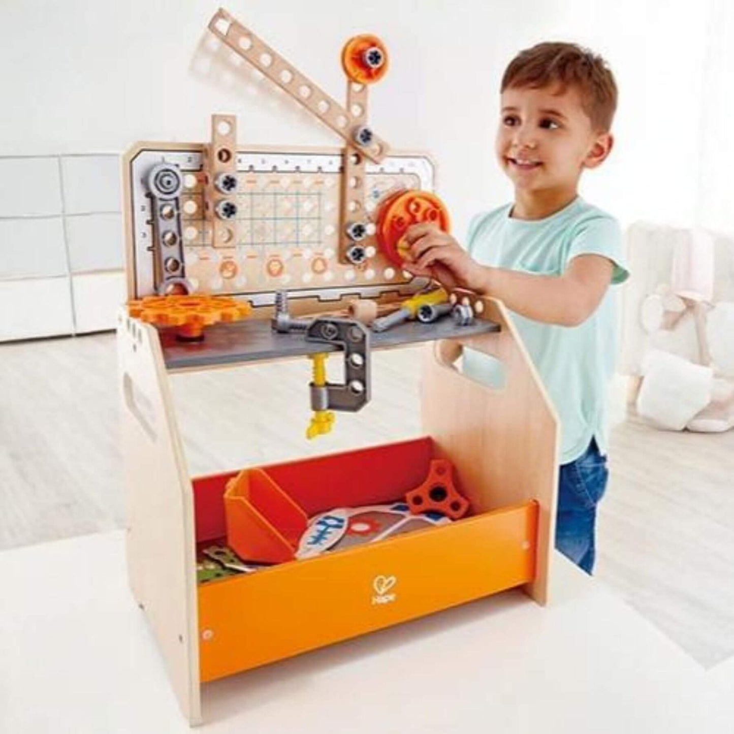 Child playing with Hape Discovery Scientific Workbench on a white surface