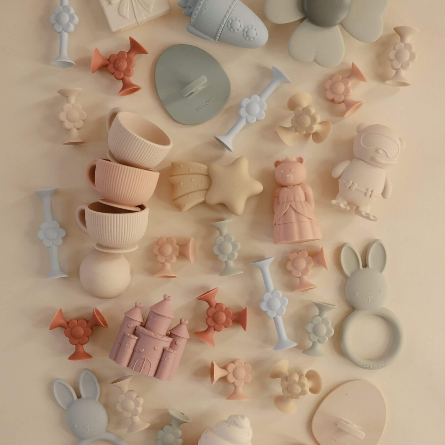 Collection of pastel-colored silicone molds on a beige background