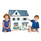 Two children sitting in front of Tender Leaf Dovetail House with a white background