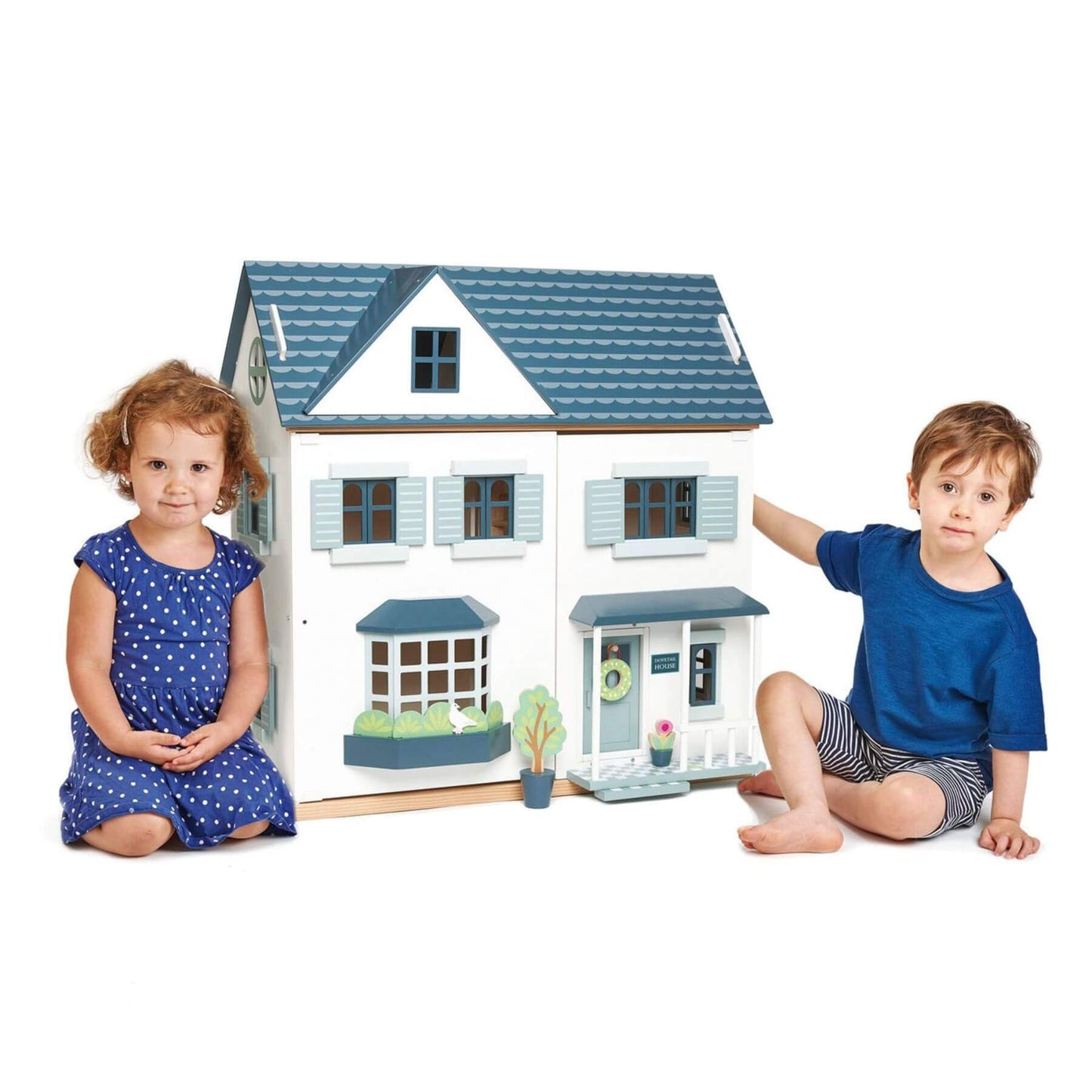 Two children sitting in front of Tender Leaf Dovetail House with a white background
