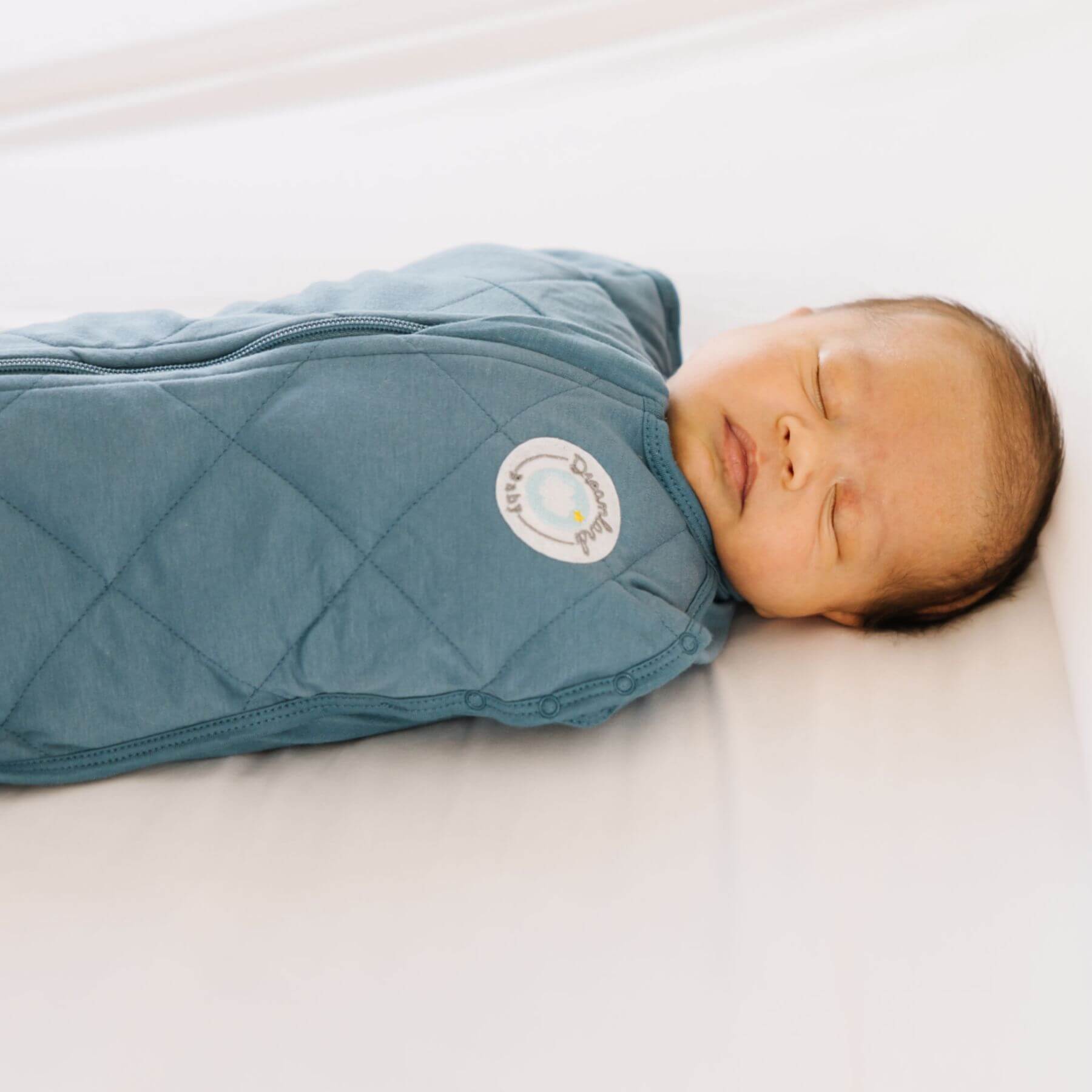 Newborn baby wrapped in Dream Weighted Sleep Swaddle - Ocean Blue