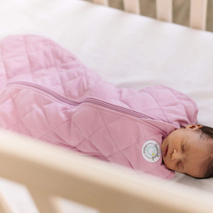 Baby sleeping in Dream Weighted Sleep Swaddle - Mauve in a crib.