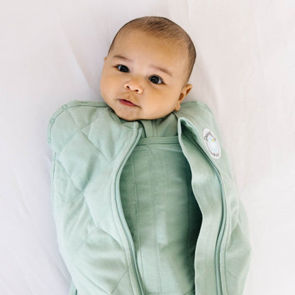 Baby wearing Dream Weighted Sleep Swaddle - Sage on a white background