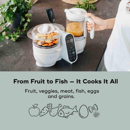 Babymoov Duo Meal Station Baby Food Maker on a kitchen counter with text highlighting its cooking capabilities.