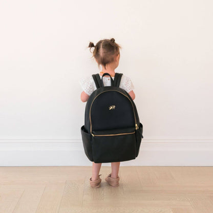 Child wearing a black backpack with a visible brand logo on a plain background