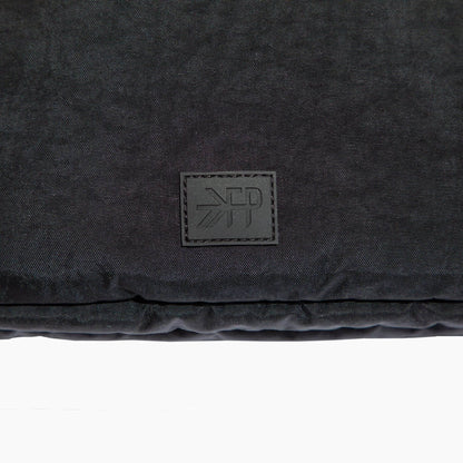 Black textured fabric with a brand logo on a white background