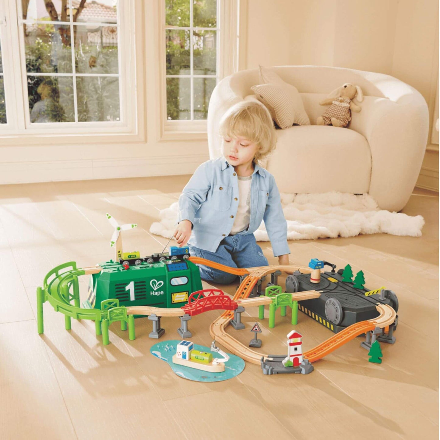 Child playing with Hape Eco Energy Train Bucket Set on a wooden floor.