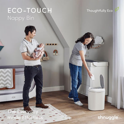 Family in a nursery with an ECO-TOUCH nappy bin, featuring 'shnuggle' branding.