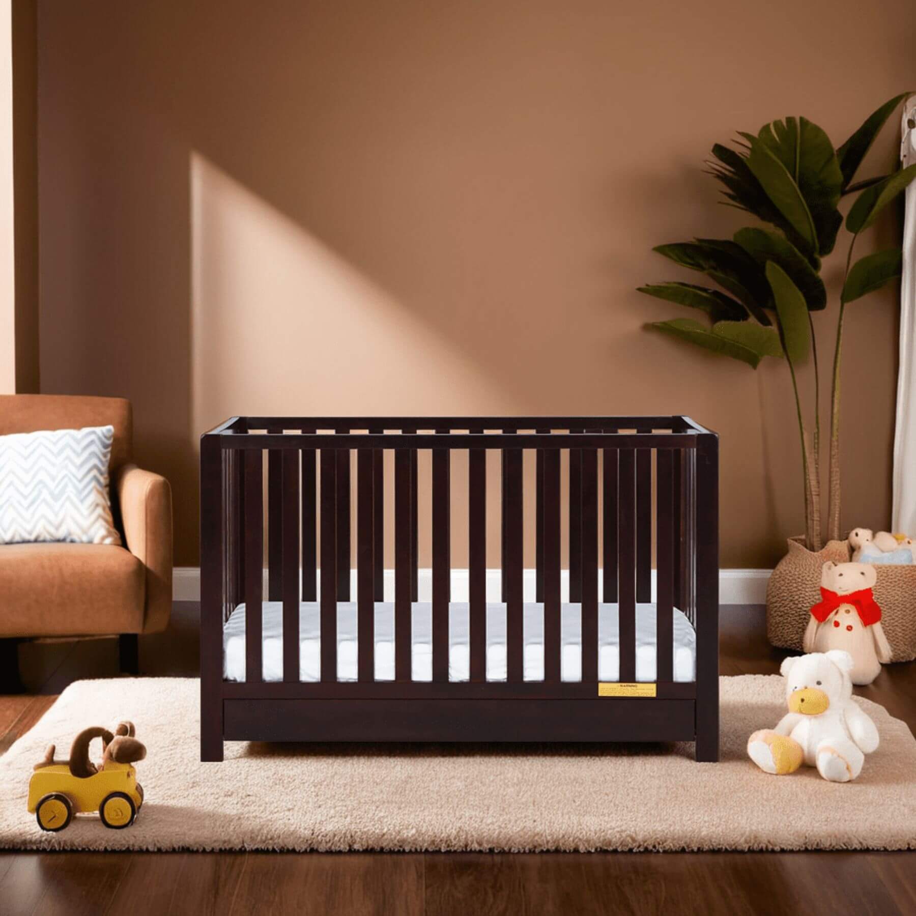 AFG Emma 4-in-1 Convertible Crib with Drawer - Charcoal in a nursery with toys and a plant