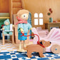 Wooden toy figure of a child with a dog in a dollhouse setting